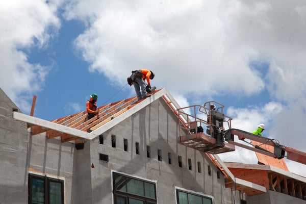 Three roofers on top of new construction home