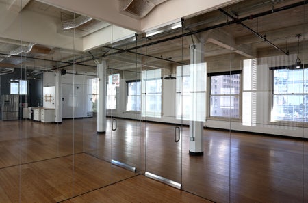 Vancant City office with glass doors, wooden floor and white columns.