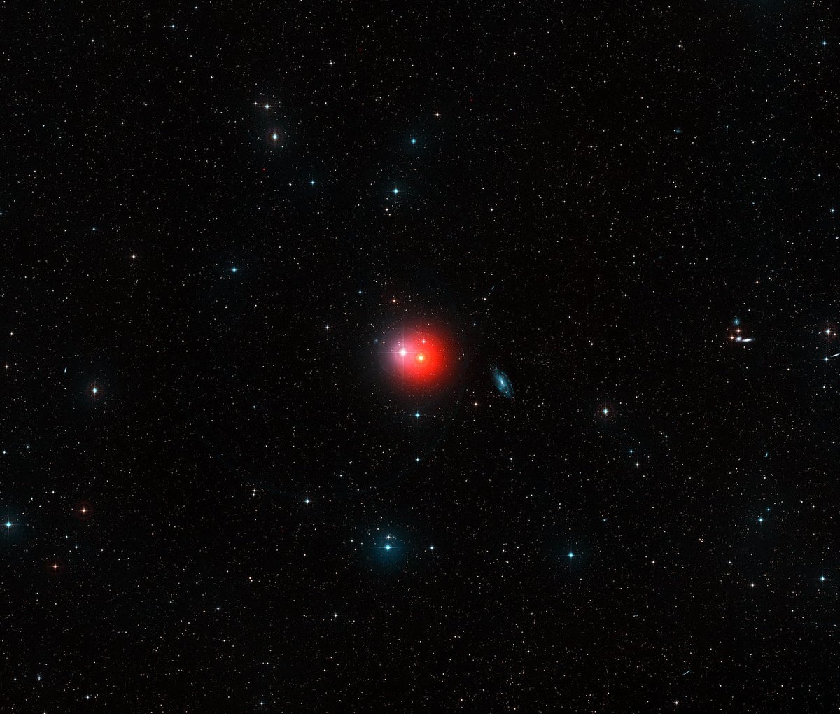 A view of the red giant star π1 Gruis as a small reddish dot in deep space.