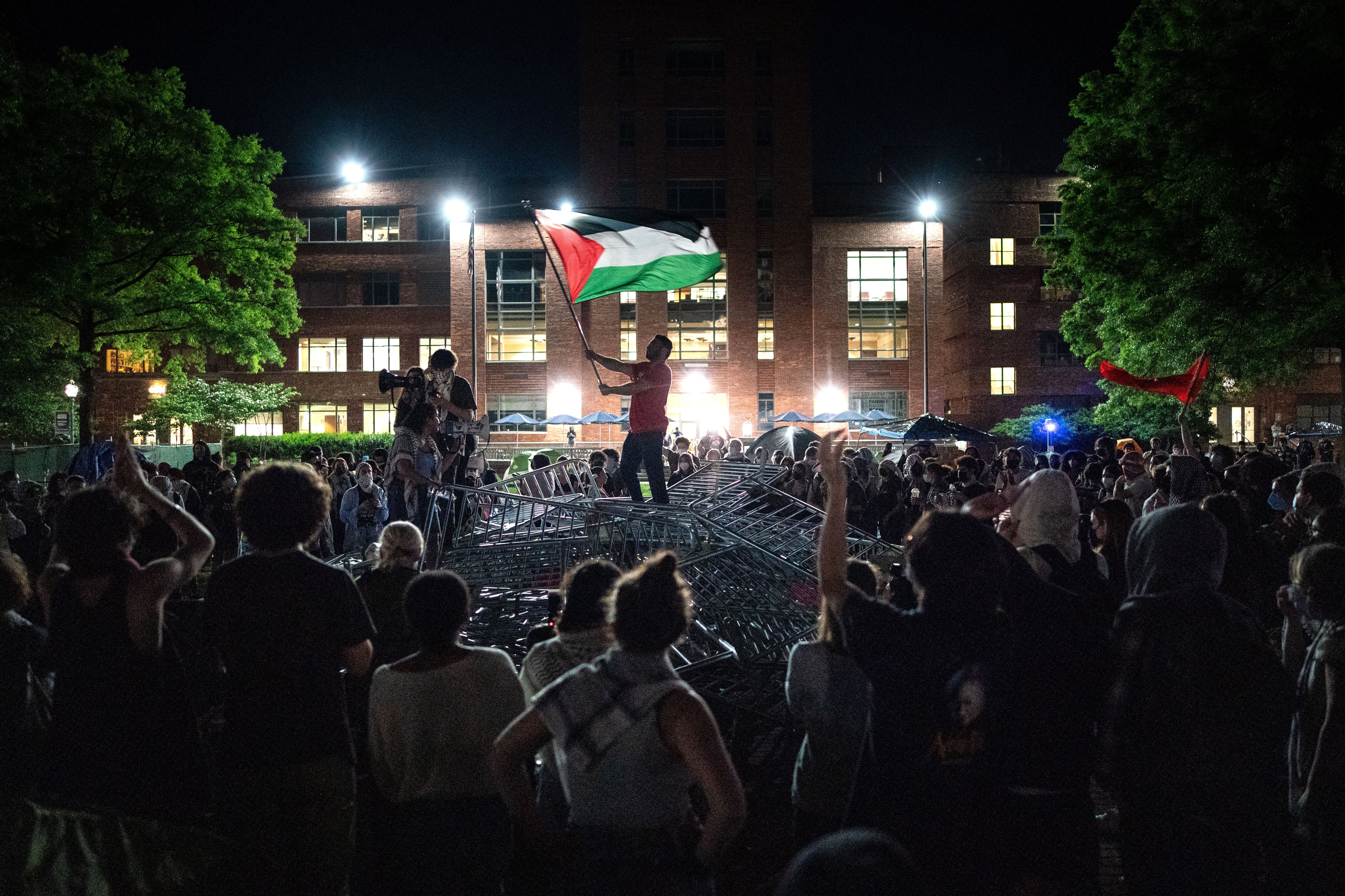 Protesters at night at the University Yard standing on top of barricades.