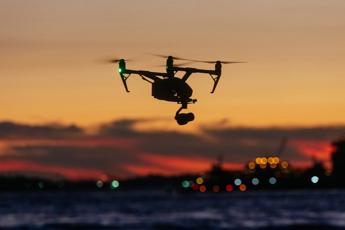 Drone flying in front of New York skyline at sunset