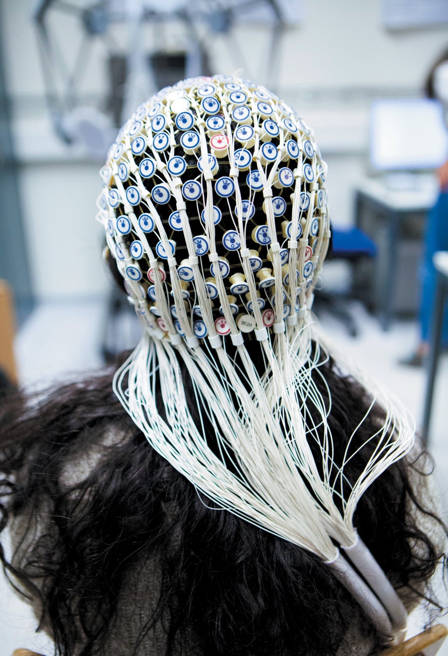 A person shown from behind wearing a head net of electrodes.