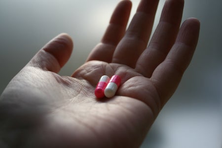 hand holding two capsules.