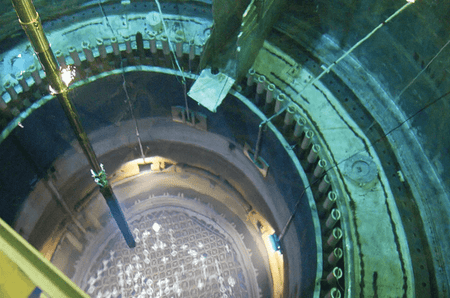A robotic arm reaches down through 70 feet of water to move a spent nuclear fuel rod inside the open core of Energy Northwest's reactor.