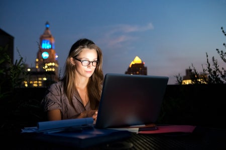 Woman working on a rooftop with laptop
