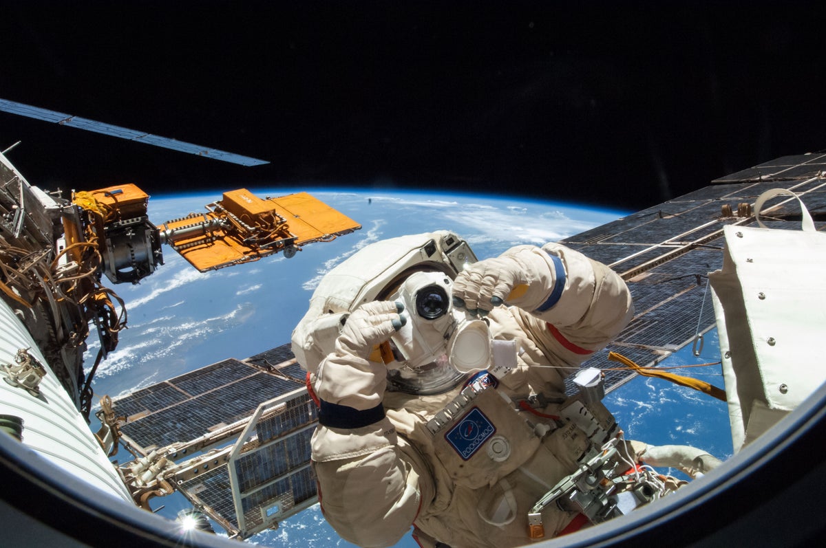 Astronaut in space holding a camera to the camera