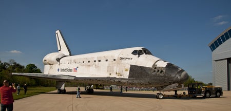 A space shuttle rolling into a hangar.