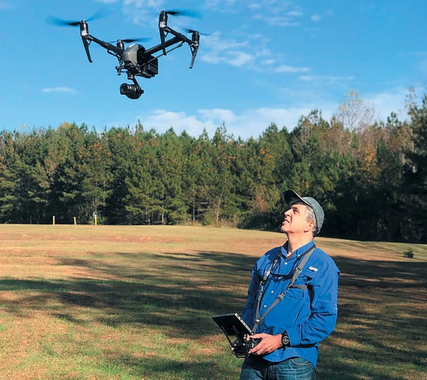 Image of a man flying a drone