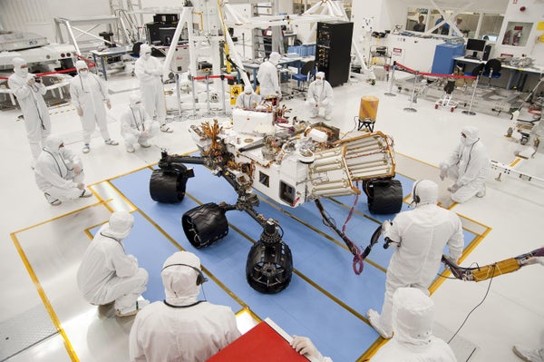 Technicians and engineers in clean-room garb monitor the first drive test of NASA's Curiosity rover, on July 23, 2010