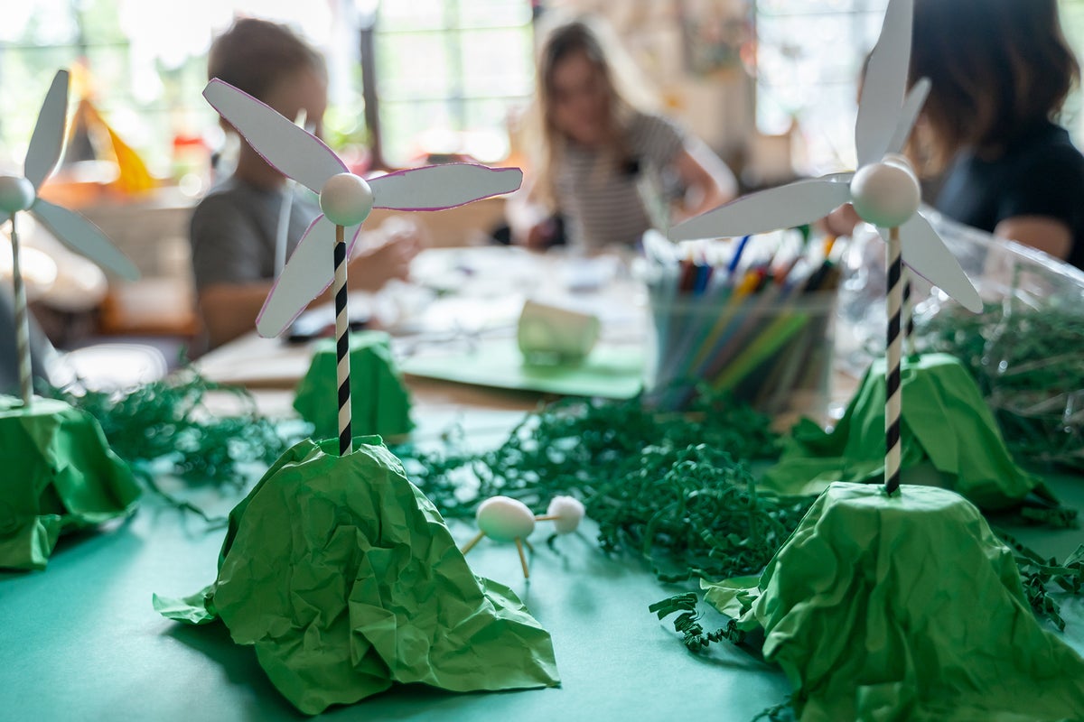 Children and teacher creating wind turbines from paper