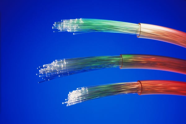 Spots of colored light appear at the end of a spray of optical fibers from a fiber-optic cable