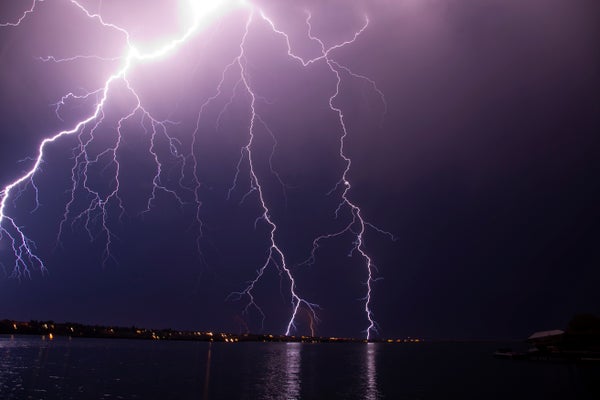 Lightning strikes over distant landscape