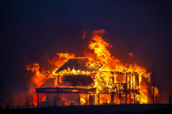 House in flames night sky.