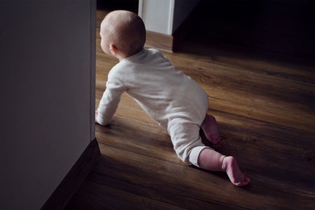 Baby crawling on floor through doorway