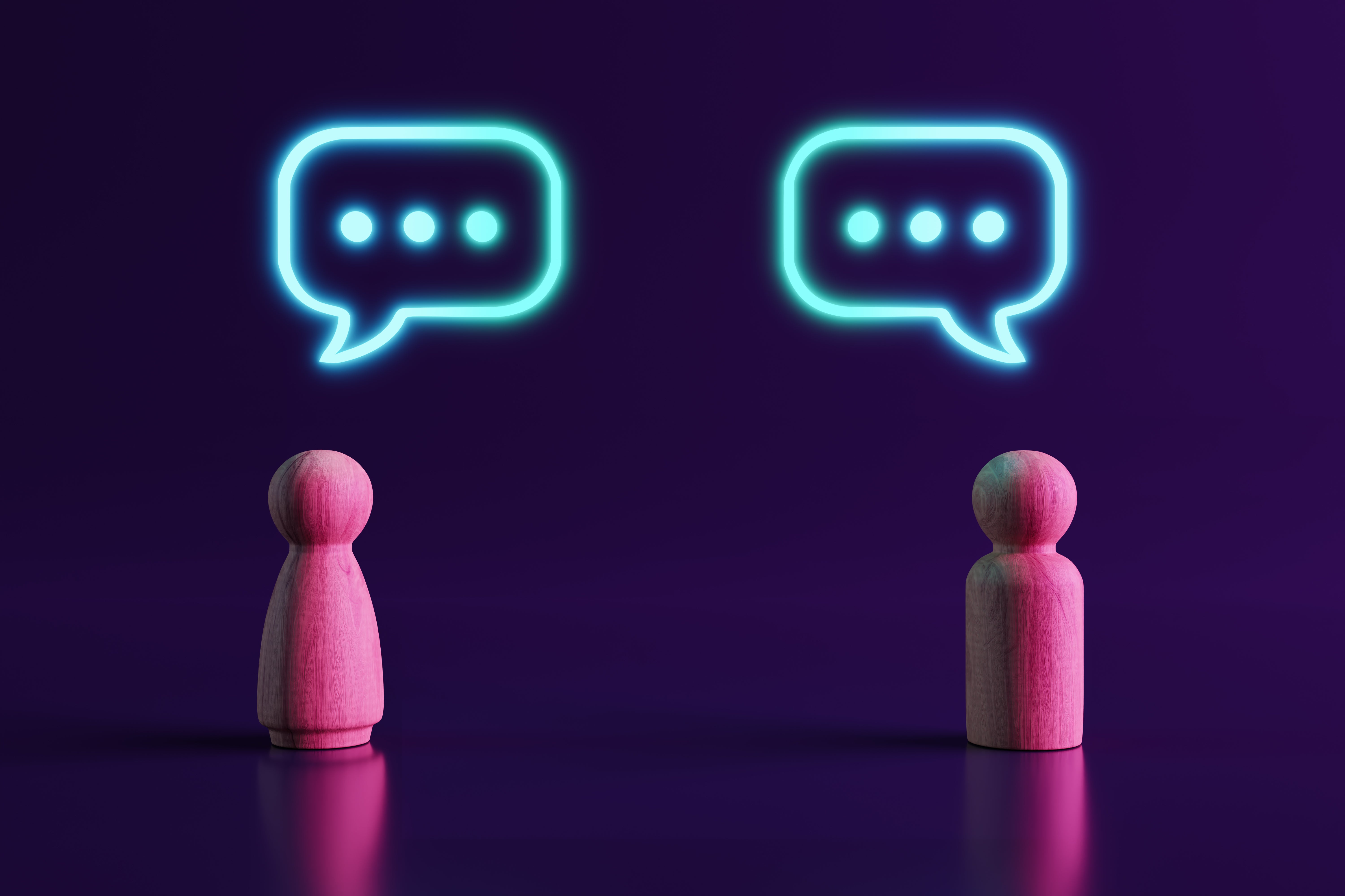 Two Wooden People Figures Communicating and 3 dots in speech bubble.