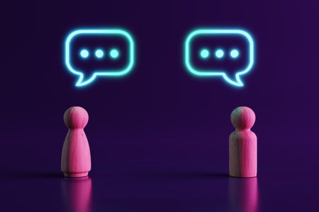 Two Wooden People Figures Communicating and 3 dots in speech bubble.