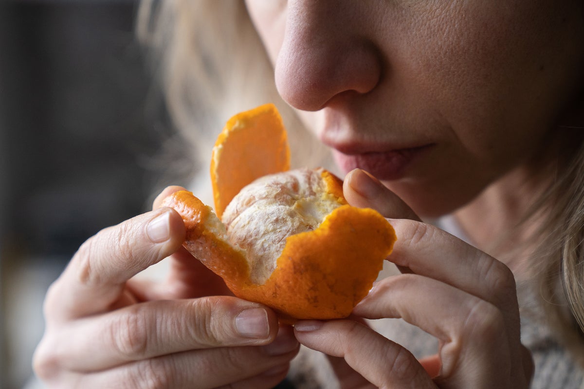 Person trying to smell an orange