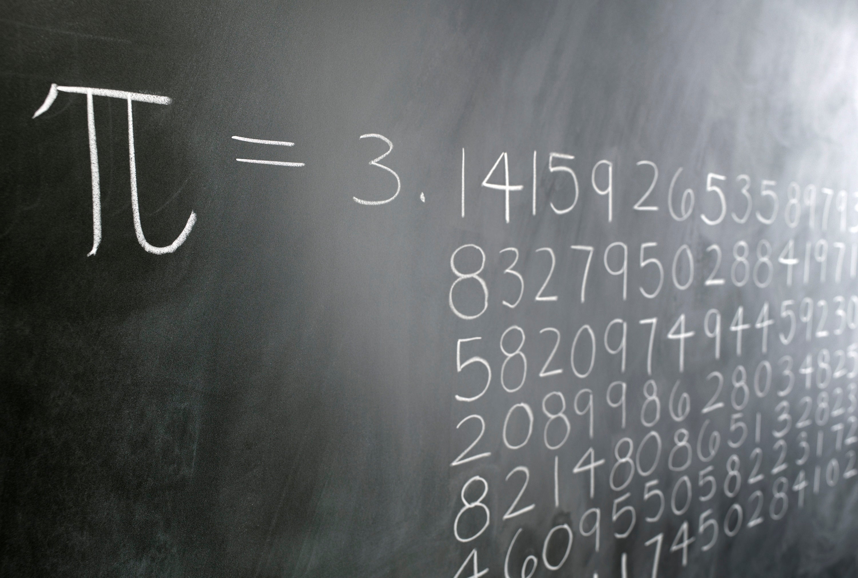 A blackboard shows the digits of pi drawn out in chalk.