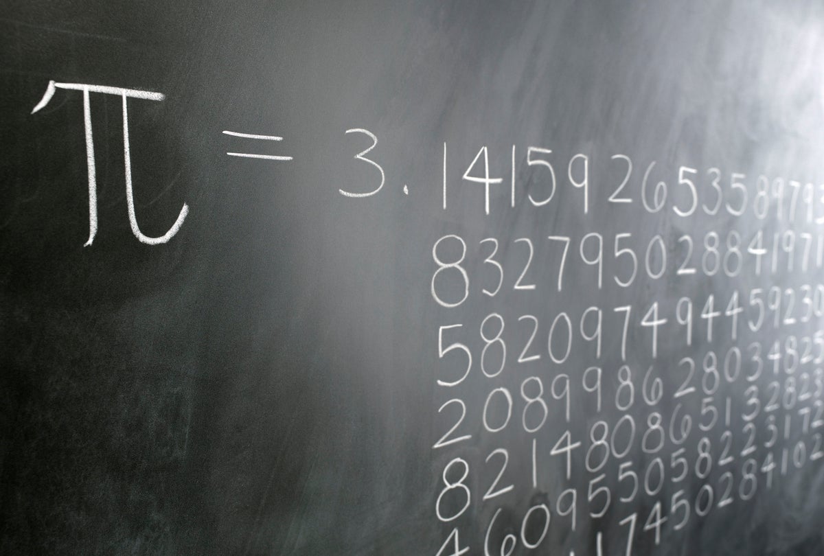 A blackboard shows the digits of pi drawn out in chalk.