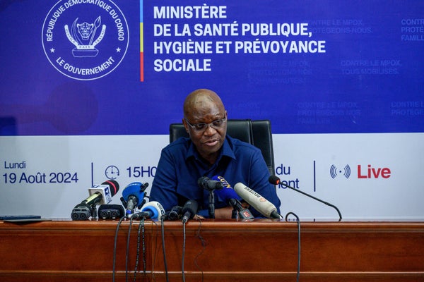 Democratic Republic of Congo Health minister Samuel-Roger Kamba sits at a podium with microphones during a press conference