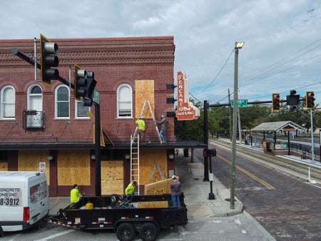 Contractors covering windows with plywood.