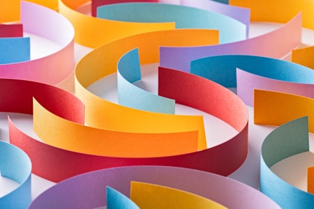 Different colored paper strips laid out in a twisting, interlocking pattern