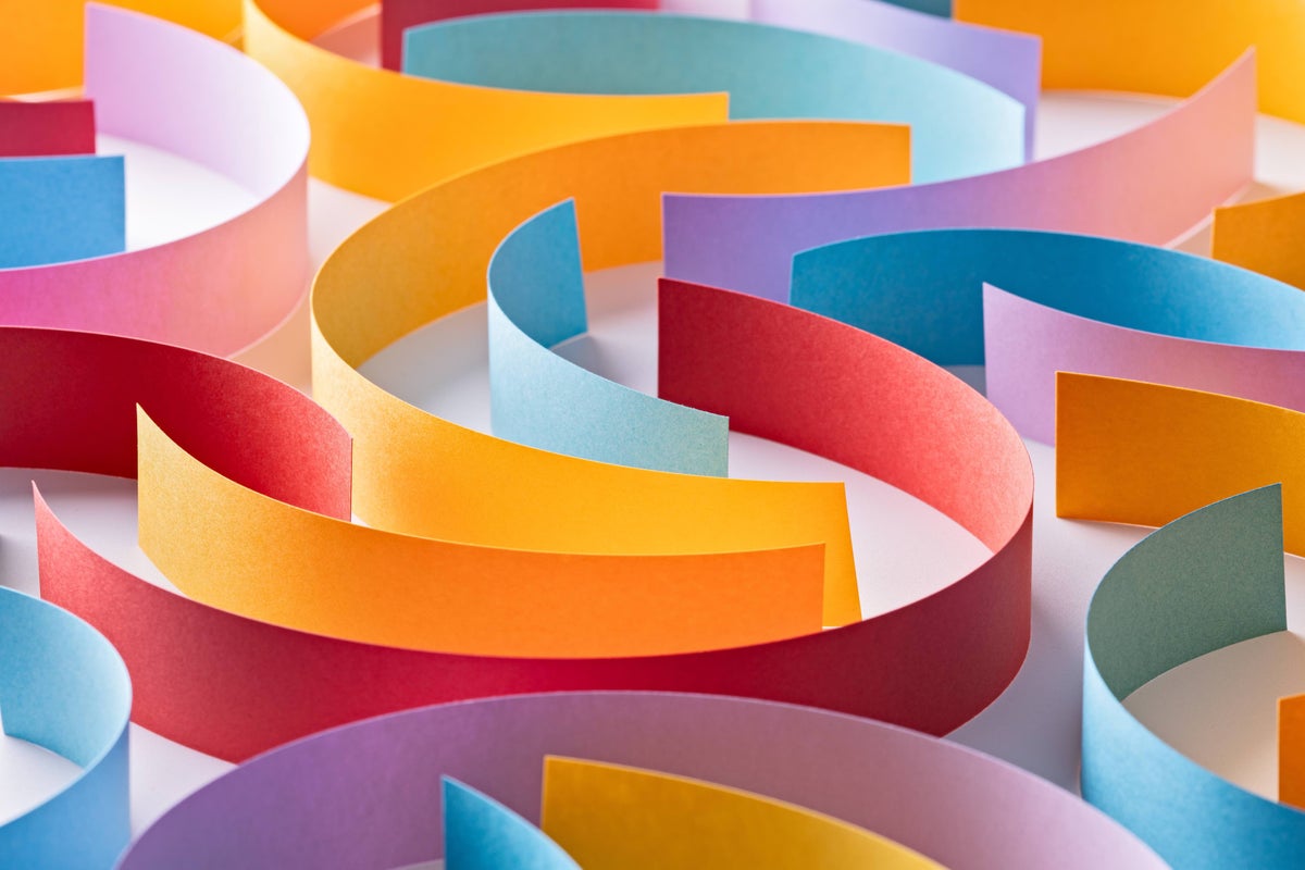 Different colored paper strips laid out in a twisting, interlocking pattern