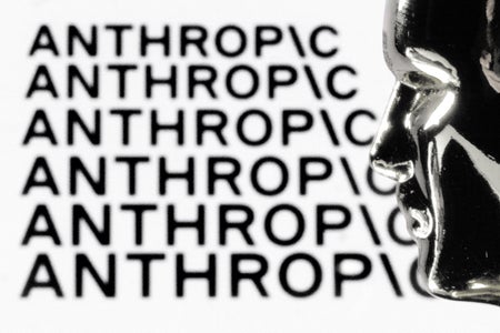 Black-and-white image of the word “ANTHROPIC” repeated in bold, slightly blurred text across the background, with a reflective metallic sculpture of a human face in profile on the right side of the frame.