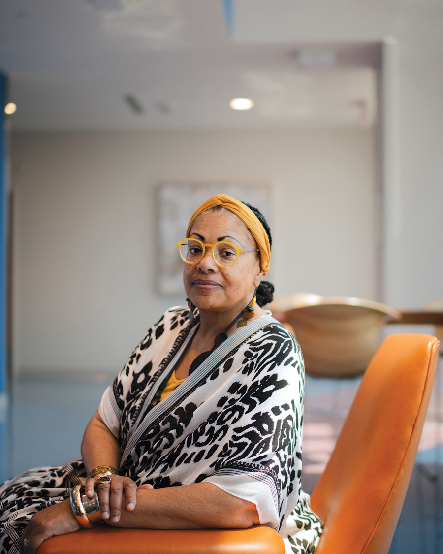 A portrait of a woman sitting in a chair looking at the camera.