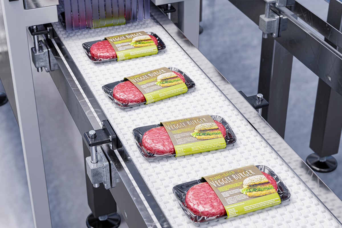 3D illustration of a conveyor belt in a food processing facility with packaged plant-based meat alternative veggie burgers