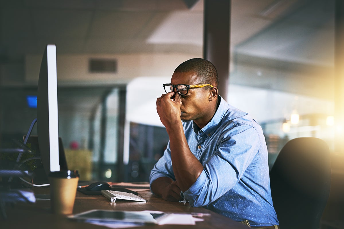 A young man experiences stress during late night at work