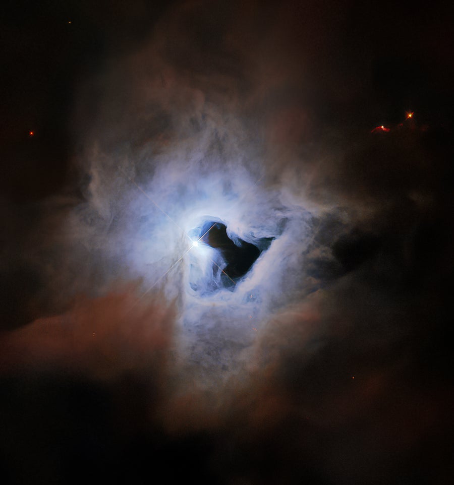 Just like fog curling around a street lamp, reflection nebulae like NGC 1999 only shine because of the light from an embedded source. In the case of NGC 1999, this source is the aforementioned newborn star V380 Orionis which is visible at the centre of this image. The most notable aspect of NGC 1999’s appearance, however, is the conspicuous hole in its centre, which resembles an inky-black keyhole of cosmic proportions.