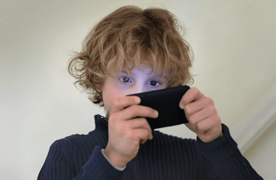Kid playing on a smartphone. 