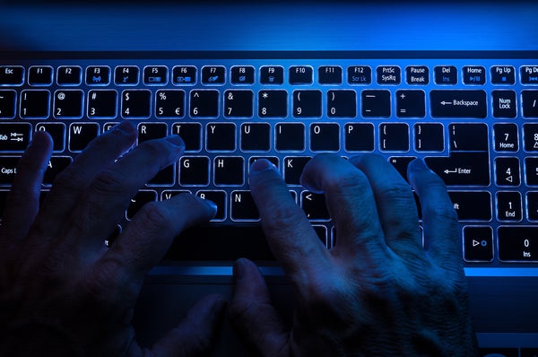 Hacker hands typing in dark blue light