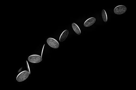 Coin flipping against black background