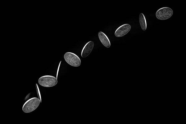 Coin flipping against black background