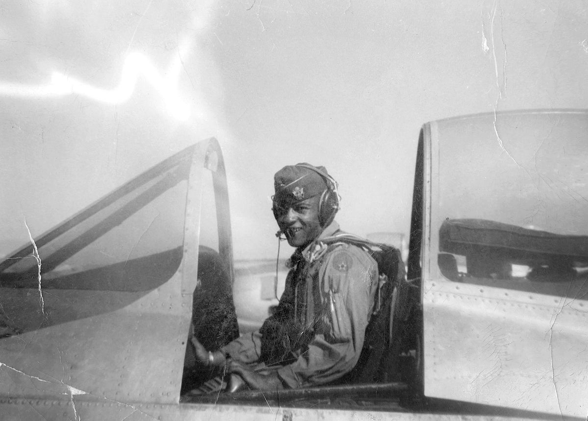 A man shown in airplane cockpit looking at the camera.