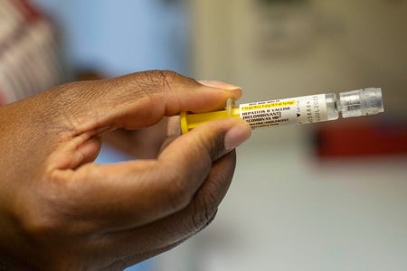 Hand holding a hepatitis B vaccine