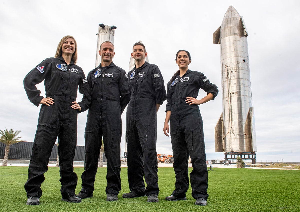 The crew of Polaris Dawn, (left to right) Anna Menon, Scott Poteet, Jared Isaacman and Sarah Gillis, pose in front of rocket stages at SpaceX's Starbase Complex in Boca Chica, Texas. A