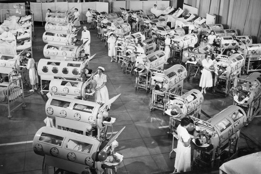 Historical 1950 black and white photo showing polio patients being treated inside 35 iron lungs lined up inside Ranchos Los Amigos Respiratory Center in Los Angeles, CA