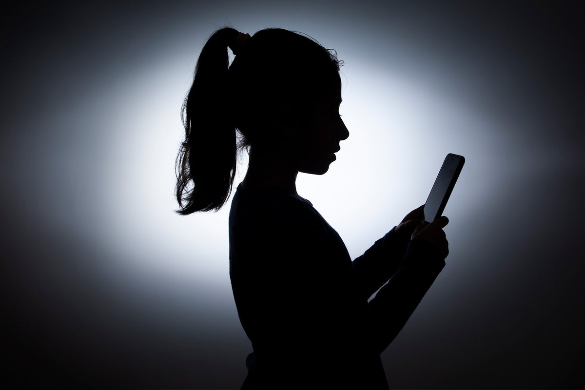 Silhouette of little girl using mobile phone