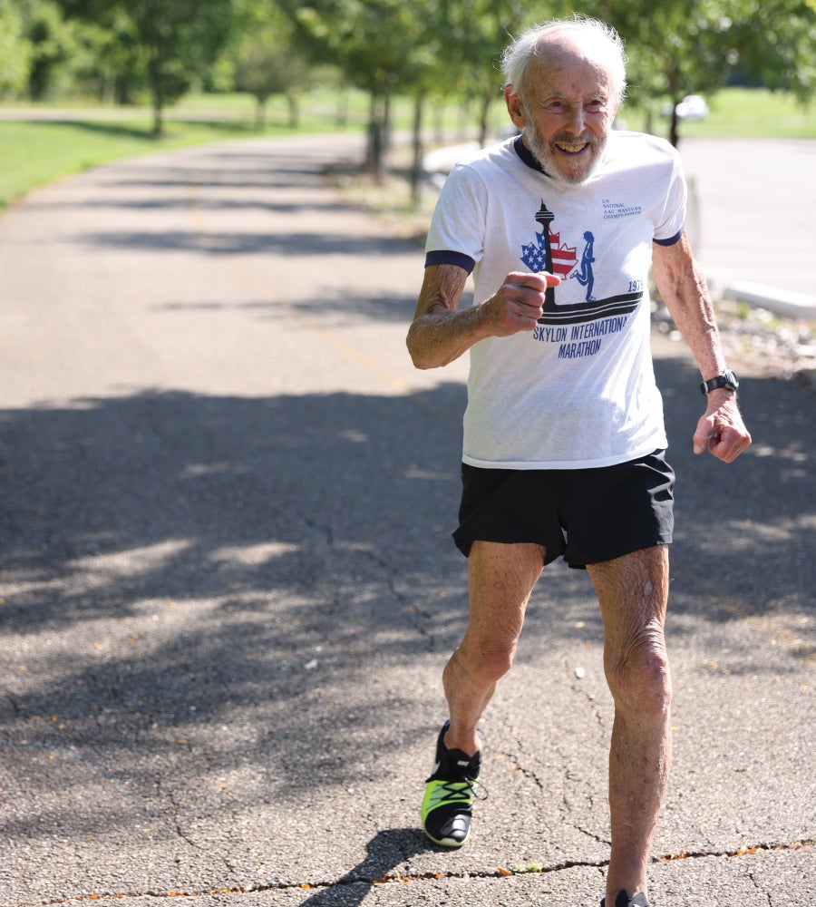 An elderly man running outdoors