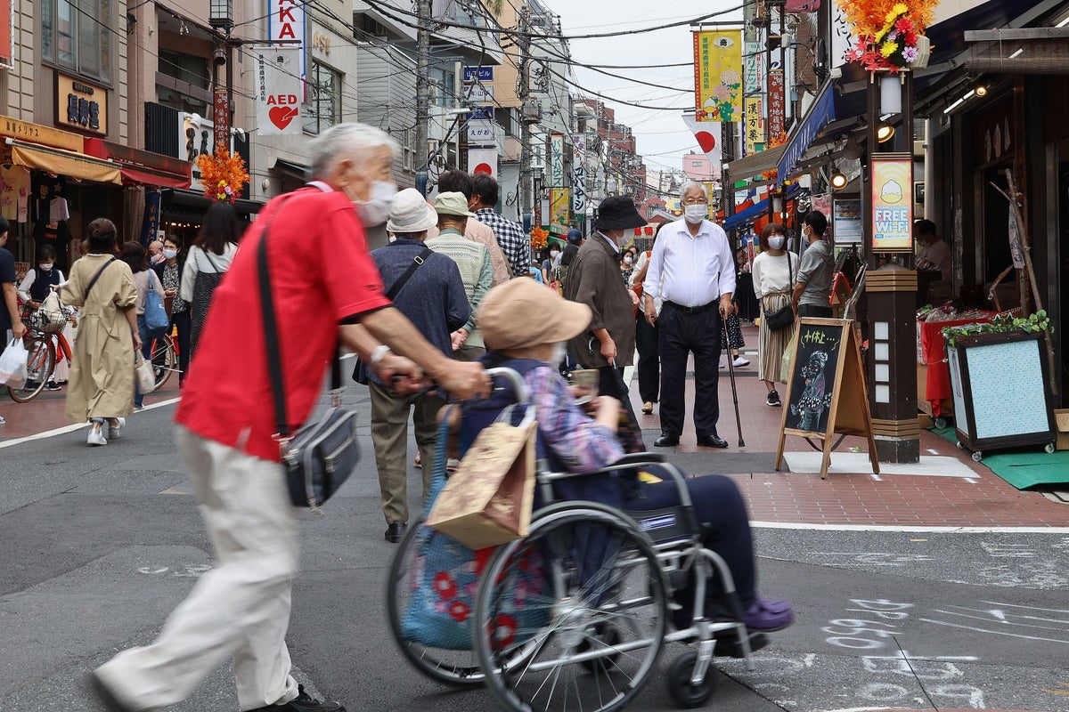 Older adults stroll at a crowded shopping street in Tokyo's Sugamo district