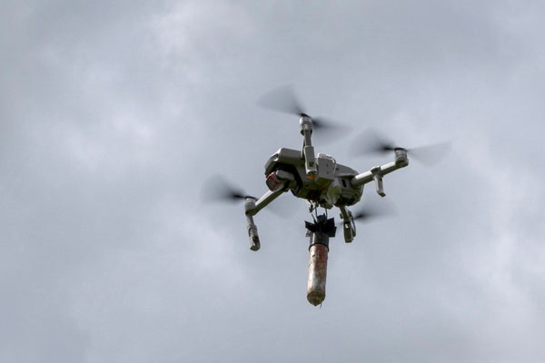 Drone in air with a bomb attached.