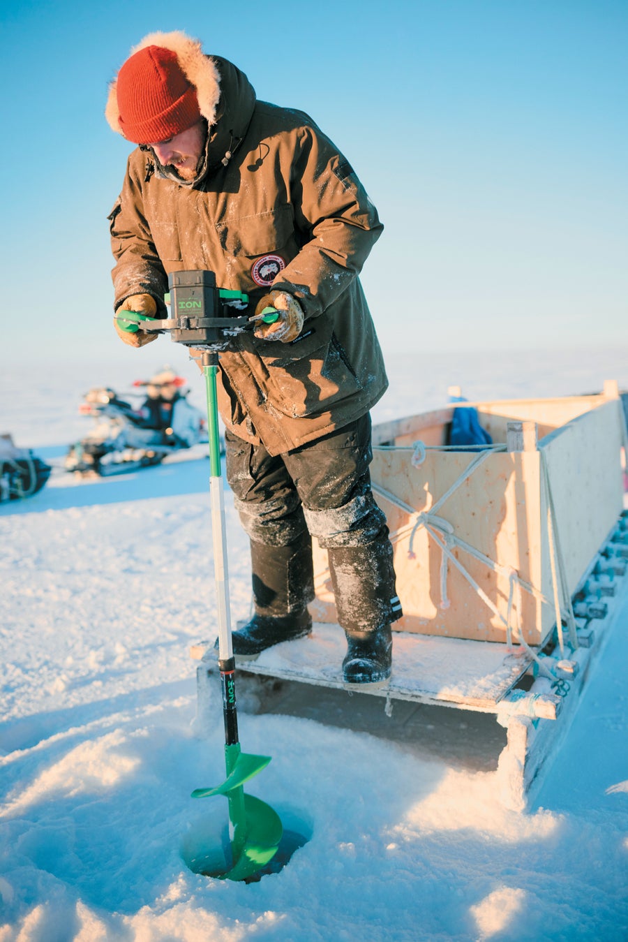 Man drilling into frozen water