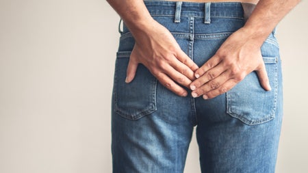 A person in blue jeans with their hands on their butt.