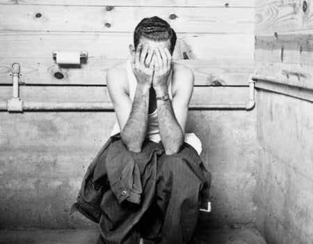 A man spends some quality time on the toilet in black and white photo