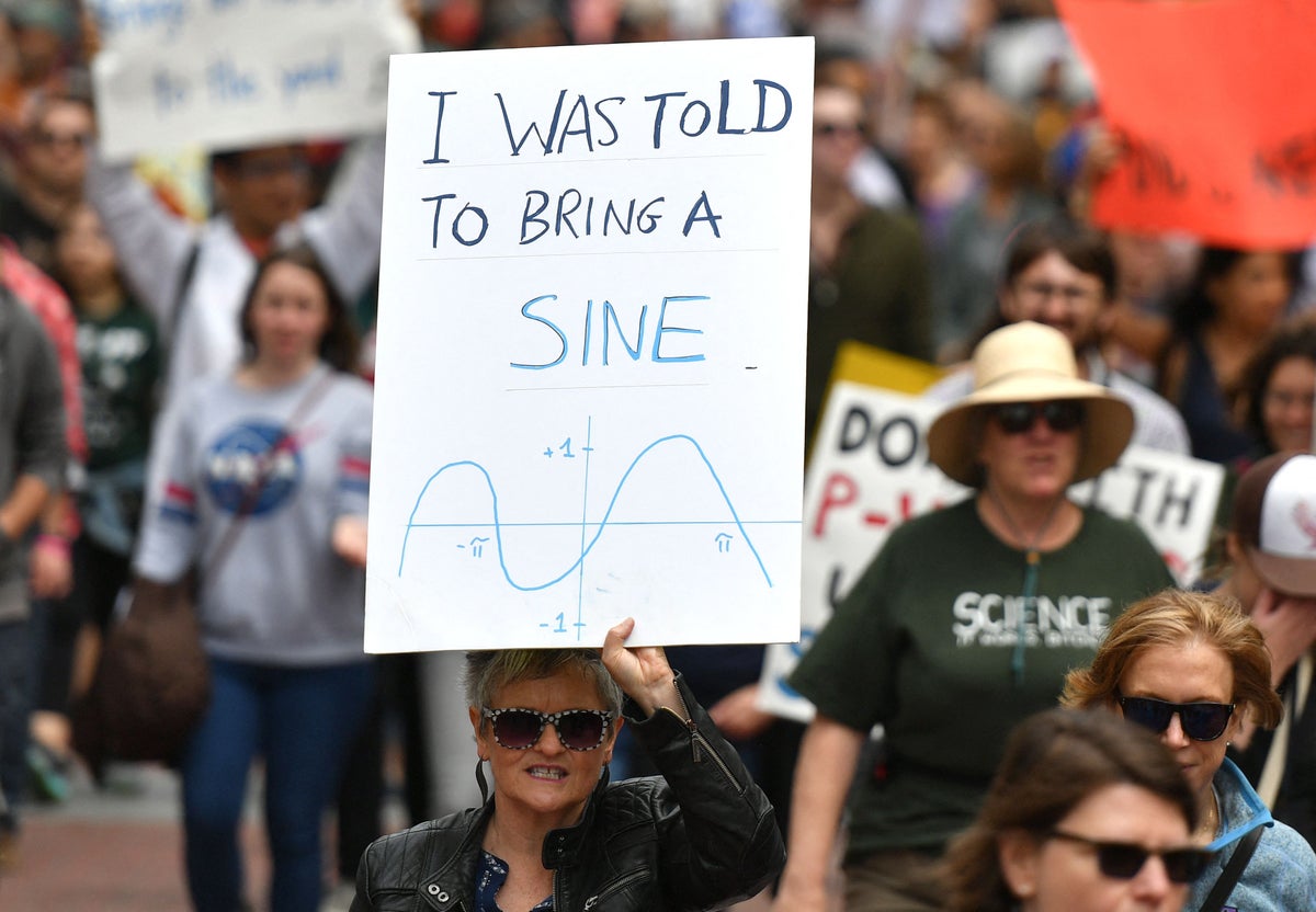 Woman at a protest march, holding a sign that says 