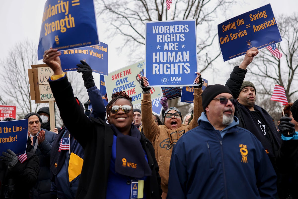 Demonstrators hold signs WORKERS RIGHTS ARE HUMAN RIGHTS