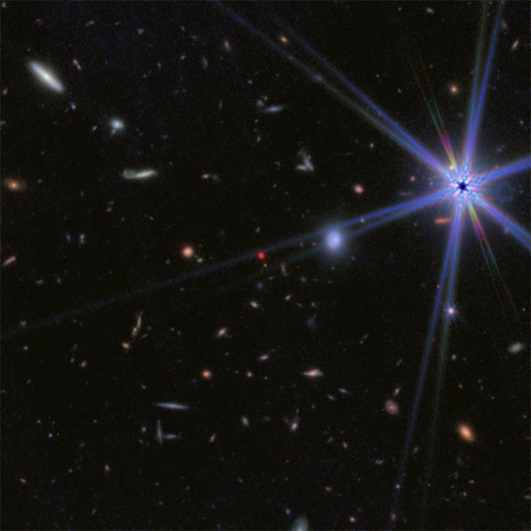 A deep field image showing many distant galaxies, including an astrophysical object known as a “little red dot” at the center.